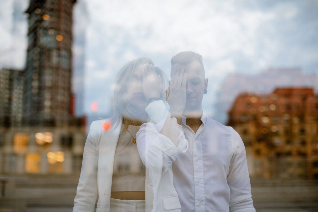 Artistic shot of a couple with their hands covering their faces at their downtown Vancouver engagement session.