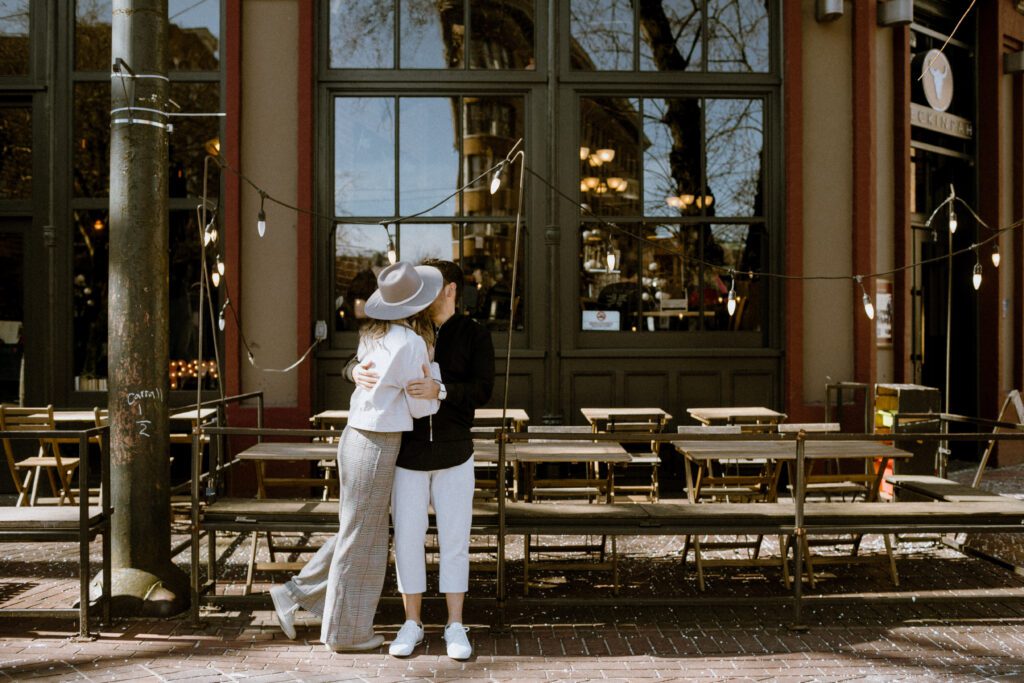 A engaged couple kissing secretively in Gastown, Vancouver.