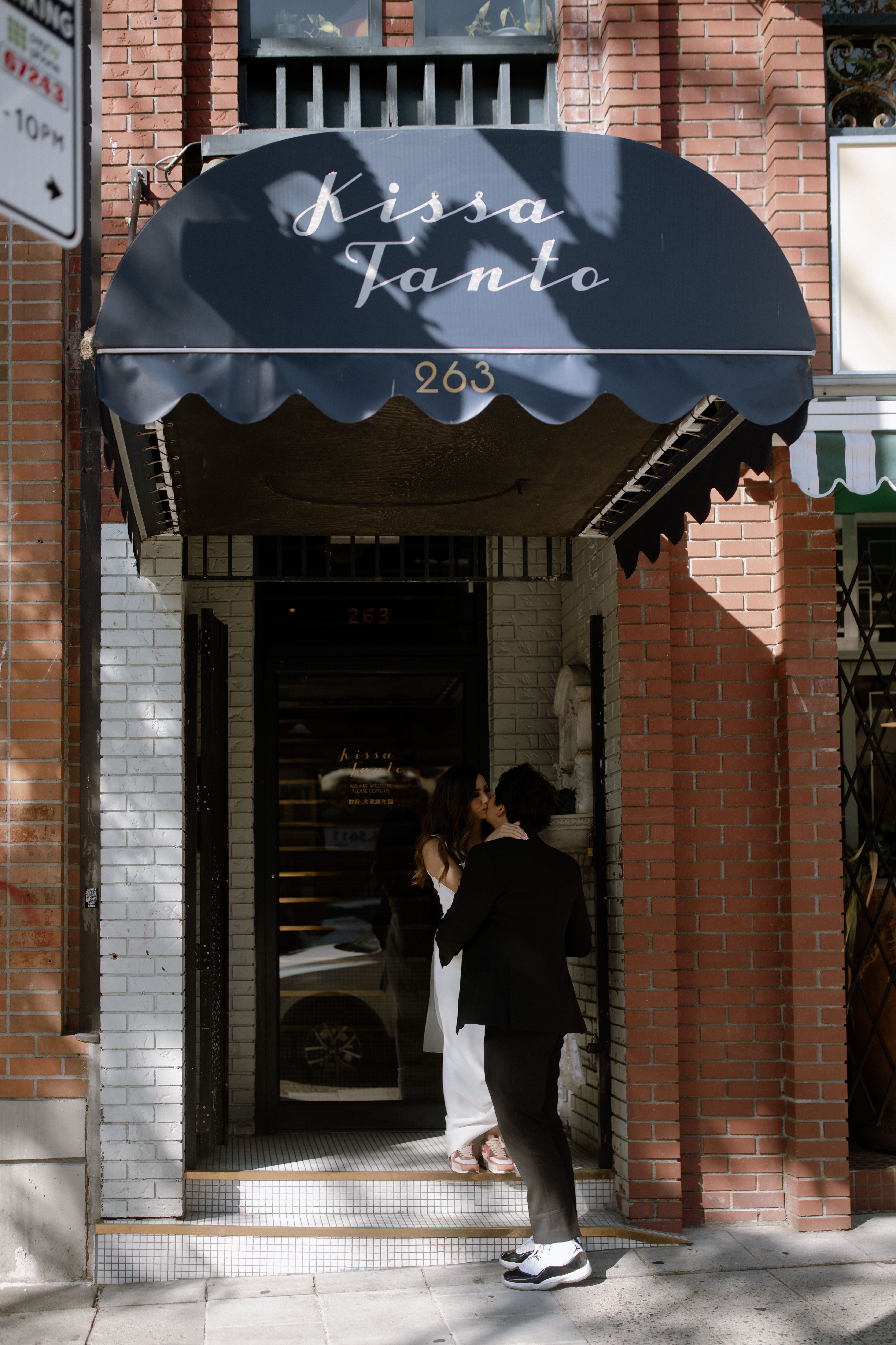 Bride and groom sharing a kiss outside Kissa Tanto in Chinatown, Vancouver