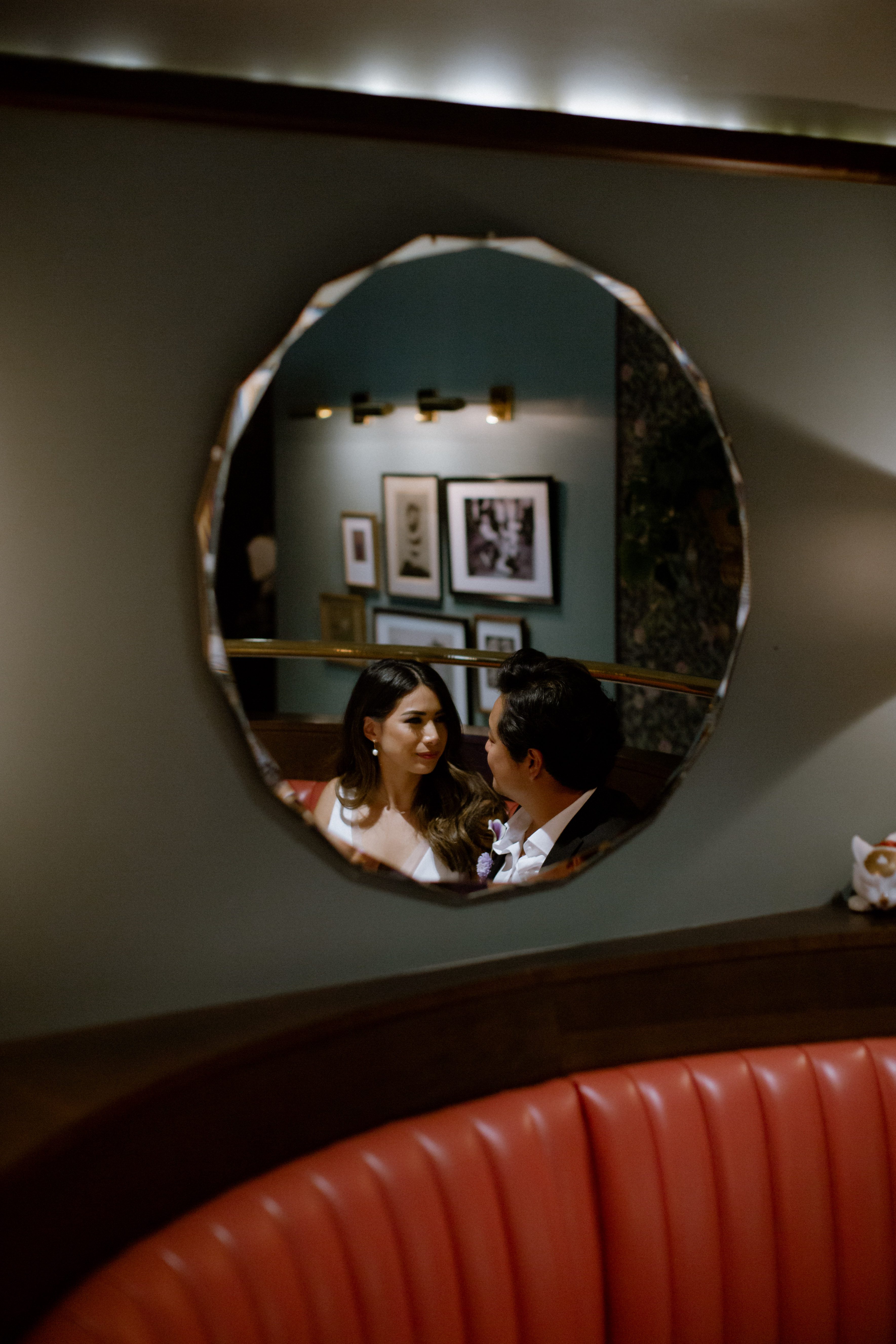 Mirror reflection of a couple gazing at each other in a dining booth at Kissa Tanto in Vancouver