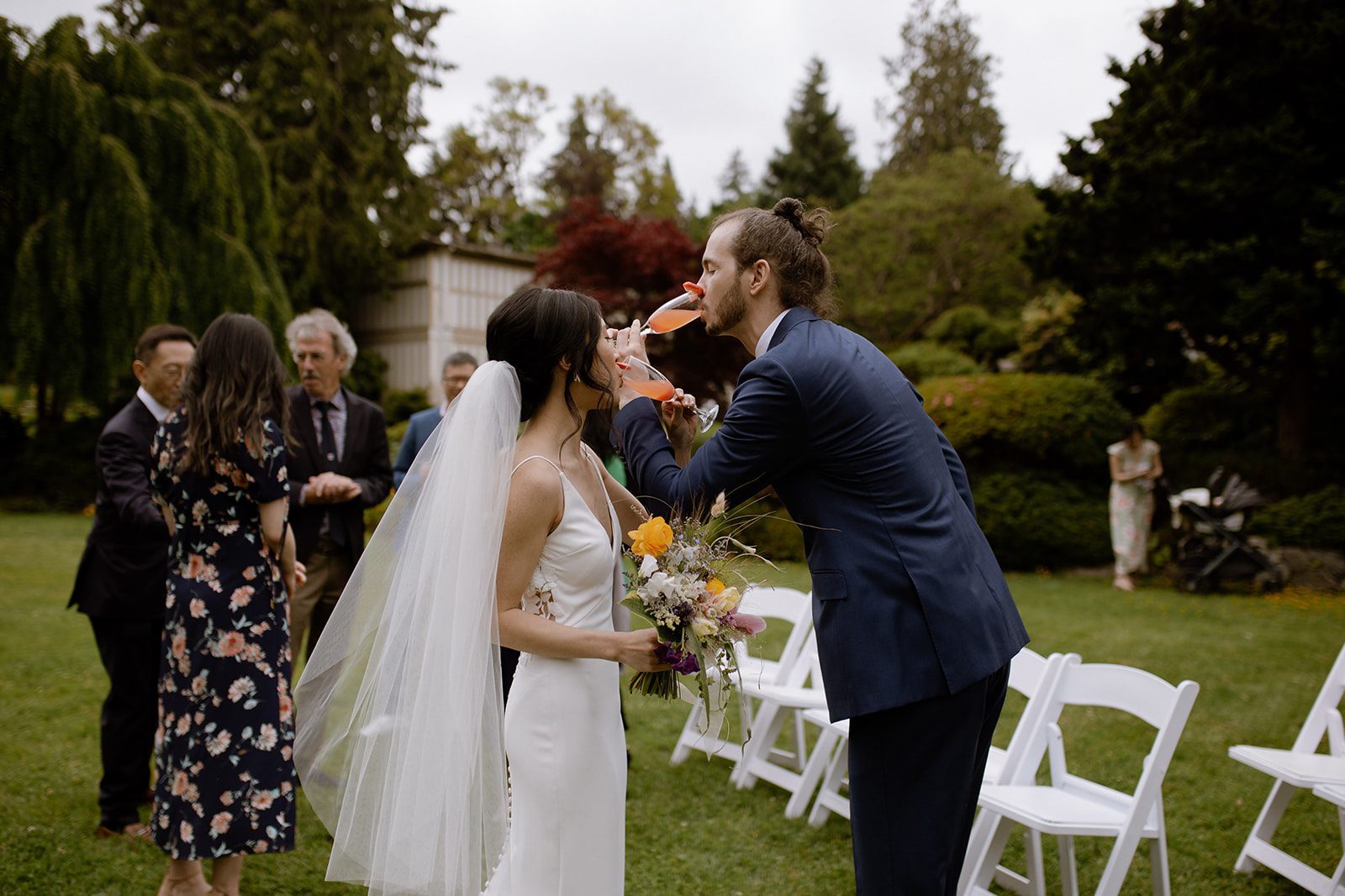 Bride and groom crossing arms while drinking their champagne at their wedding in Cecil Green Park House.