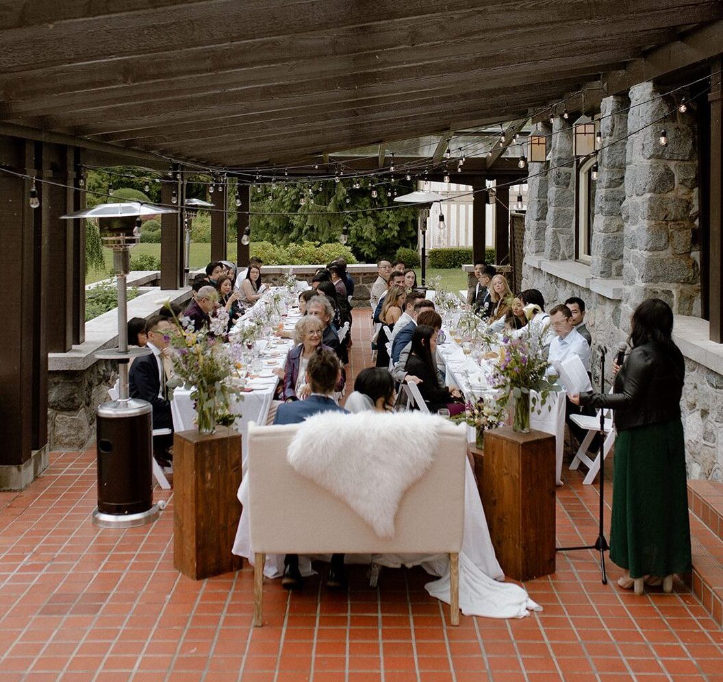 Bride and groom facing their guests during their wedding lunch reception at Cecil Green Park House